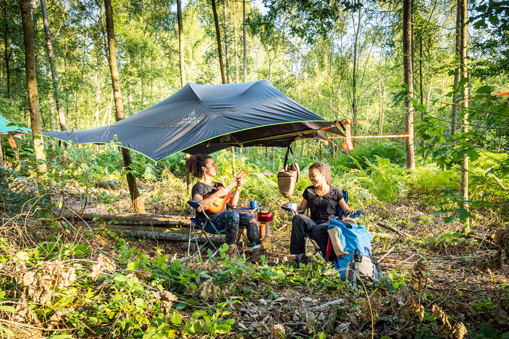 woman playing guitar at campsite (4354219573321)