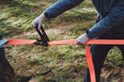 man using ratchet strap on tree (6650769768521)